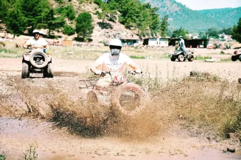 Close-up of a muddy quad bike tyre on a rugged holiday safari track in Marmaris, Turkey.