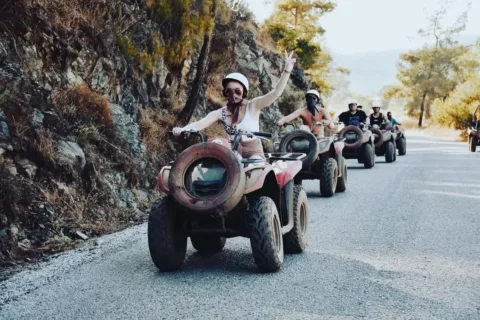 Tourists riding quad bikes along a scenic, dusty mountain trail during a Marmaris quad safari excursion.